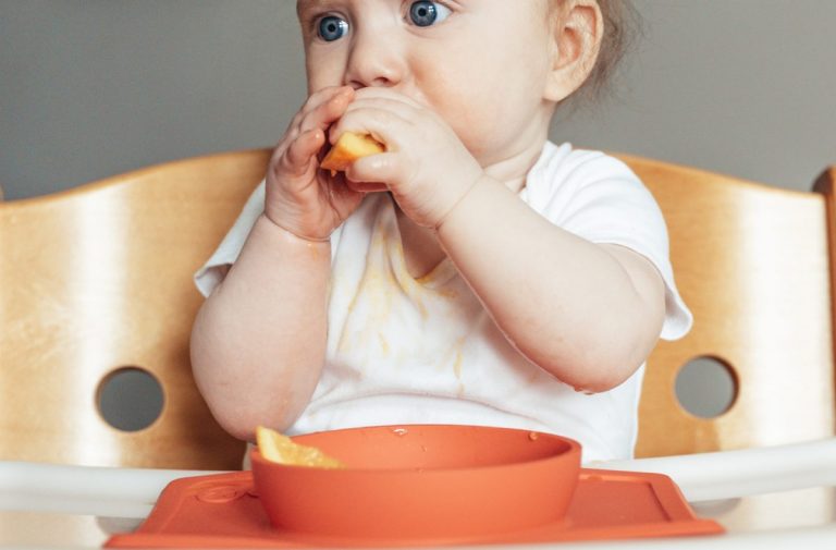 bebé comiendo en una trona